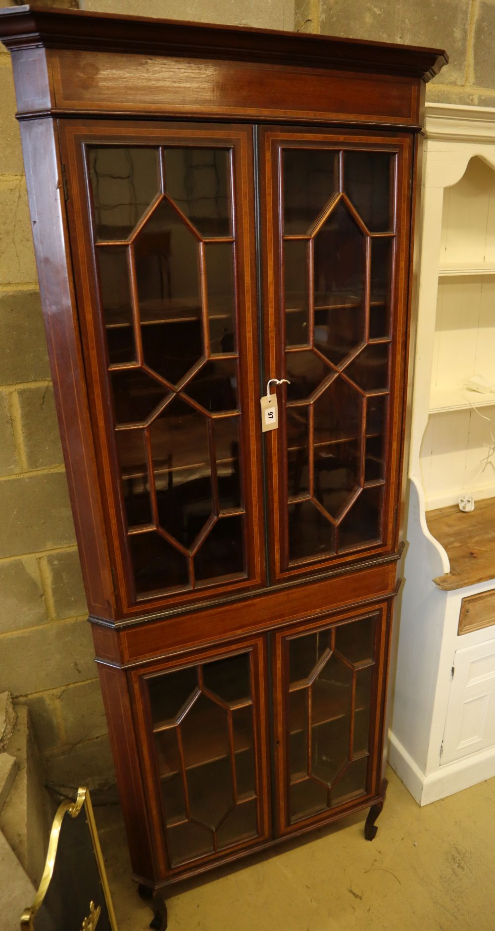 An Edwardian Sheraton revival mahogany and satinwood crossbanded corner display cabinet, on cabriole legs, W.74cm, D.37cm, H.203cm